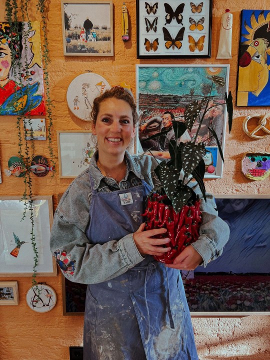 Joice in haar atelier met de peper-vaas voor haar kunstmuur